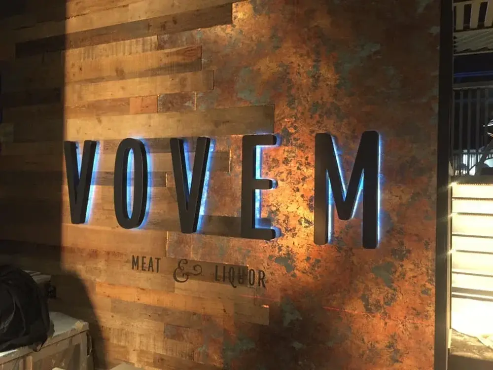 Illuminated Vovem lettering on a brick wall